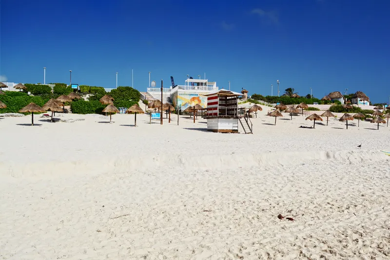 Sand, palapas and a lifeguard tower at Playa Delfines, Cancún
